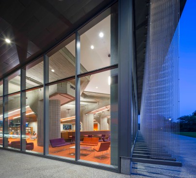 with an un-insulated building envelope and aging infrastructure, the building’s energy performance was a considerable burden. stainless steel tensioned sun-shading fins wrap the interior composition in a shimmering veil of reflected light reminiscent of the ‘disco era’ curtains once installed at the 2-story glazing. large glass windows connect inside with outside, commemorating and honoring the previous concrete structure. 