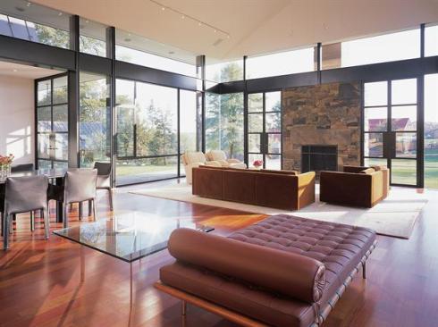 Massive steel beams and double-glazed glass protect against the wind that whips around the living room walls. In nicer weather, French doors and operable windows permit the owners to transform the space into an almost-outdoor room.