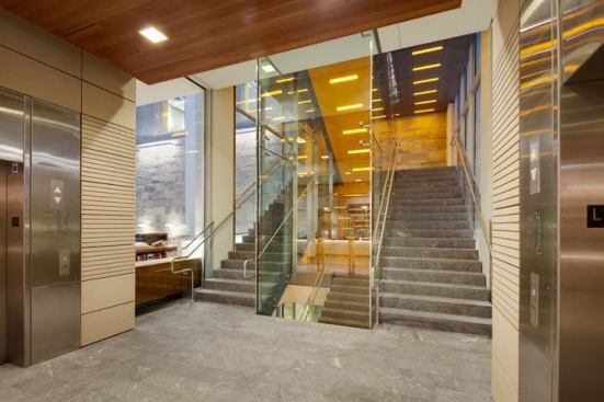 The building’s main feature stair is illuminated with a combination of custom amber and white LEDs. With the use of photosensors and programmed presets, the 0.5W LEDs change color and intensity­from white to warm­as the day progresses. 