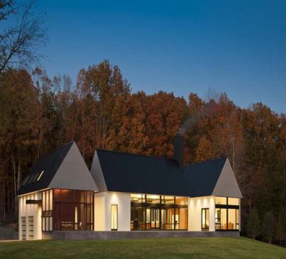 Bercher House  Award of Excellence 
Robert M. Gurney Architect Becherer House in Charlottesville, Va., was designed by Robert M. Gurney Architect and offers views of the Albemarle County, Va., countryside and a wooded area via two glass walls in the central living area—a construction that also allows for ample natural light. A screened porch and bluestone terrace run the length of the house, and join the standing seam black metal gable roofs and clapboard siding for a contemporary rural aesthetic.