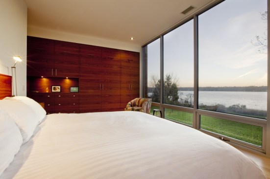 As in the main living space, the main feature of the master bedroom is the river, along with a wall of walnut paneled cabinetry