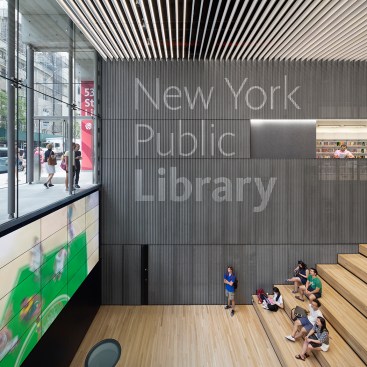 The library glows from within via the vast monolithic ceiling made up of high-performance continuous LED channels tucked behind white baffles.