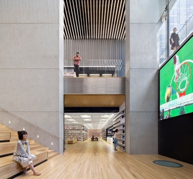 The luminous quality of the main floor ceiling continues into the reading room with a metal mesh ceiling.