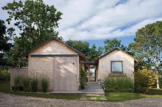 A bike shed and a guest house compose the home's street elevation.
