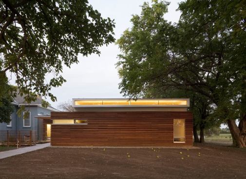 Exterior view of the back of the building. The design approach layers architectural form, material, and light into a sophisticated composition.