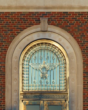 The+bronze+doors+and+eagle+grill+glow+from+reflective+light.