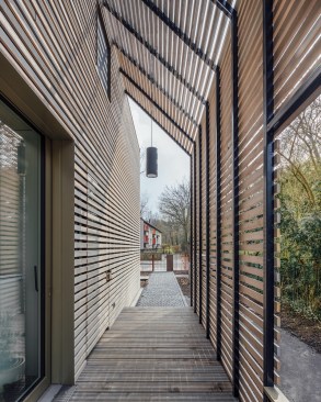 The house entrance is protected from sun, wind and weather by the pergola above.