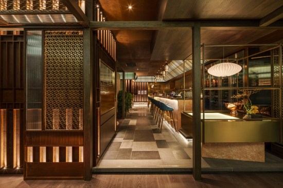 Oak wood frames contain copper and brass screens, which divide spaces and reflect light throughout the restaurant. 