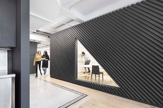 A striated volume for large meetings organizes the spaces around it. Triangular windows are cut on the diagonal yielding non-normative views into and out of the space.