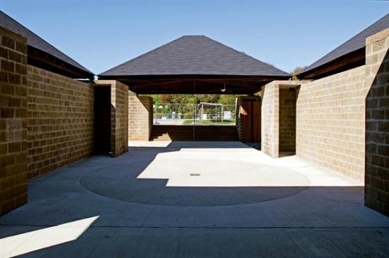 Now completed, the central courtyard of the bath house features both cleaned and new concrete block, and a darker exposed-aggregate concrete in place of the formerly inset gravel circle. The roofs were restored to their original dark tab shingles.