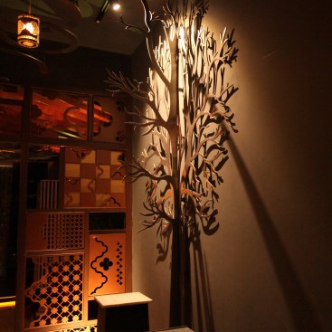 A tree made for stainless steel sheets forming an enhancing the outdoor night garden display area
