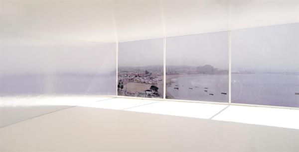 View of gallery with view out through sliding glass wall to ocean beyond.