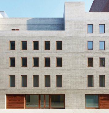 The exposed concrete façade references the neighborhood’s industrial past.