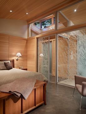 A glass partition, pocket door, and clerestory allow the master bedroom to share light with the dressing area and master bath.