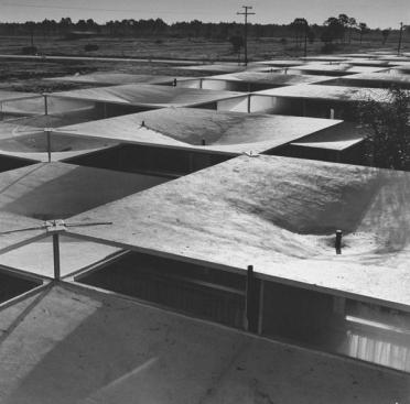 Overview+of+parasol+roof+from+above%2c+made+of+75+concrete+umbrellas+joined+with+plastic+at+new+resort+motel.