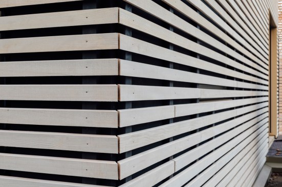 The façades and roof surfaces are covered with delicate, light-coloured wood lathing made of silver fir.