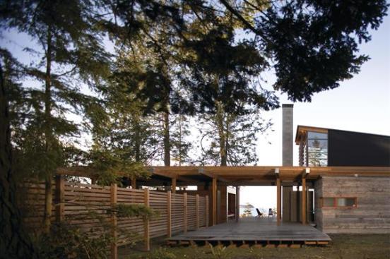 The entry path steps up and turns onto a breezeway deck, revealing views of the Strait of Juan de Fuca.