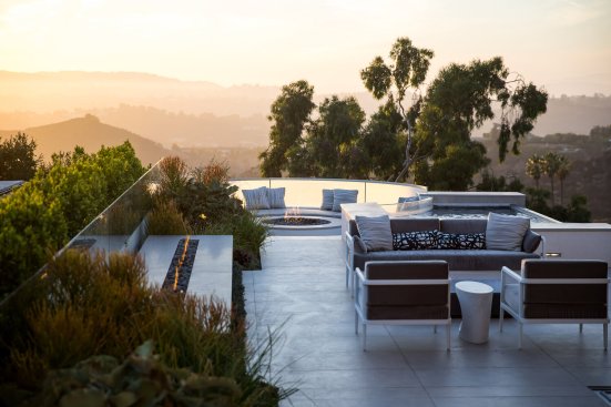 Beverly Hills modern home backyard terrace fire pit with sunset views.