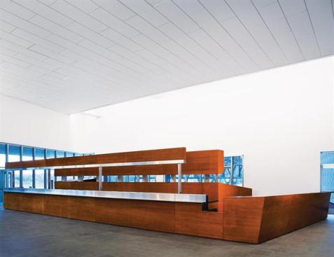 The main lobby of the noncommercial vehicle building at the Land Port of Entry is where bus passengers and others stop to show passports and get processed through border control. One of the few public spaces in the complex, the space features a bamboo and stainless steel document-processing desk behind which the border control officers sit. Workstations are concealed by a bamboo wall behind the main desk; a break in the wall allows officers seated at those workstations to have 360-degree visibility. A similar but smaller desk can be found in the public lobby of the commercial traffic building next door.