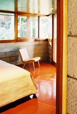 The restoration included refurbishing original red concrete floors, shown here in the guest room. 