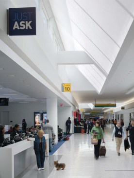 The concourses are peppered with information stations and concessions. White walls and light-colored flooring allow JetBlue?s signature blue and other accent colors to pop.