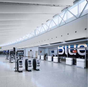 Upon arriving at the new building, travelers come to the main ticketing hall, an expansive curving space that mimics follows the arc of the roadway outside. Clerestories admit natural light, and a canted ceiling is one of the signature architectural features.