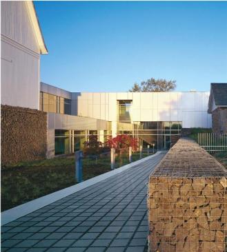 The primary entrance for the staff is at the lower courtyard level, accessed via an outdoor ramp adjacent to the barn. The barn houses the staff lunchroom and mechanical equipment-recapturing the barn's traditional role as primary support structure for the complex.