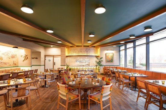 Moving into a single-height dining room, the rustic aesthetic remains reminiscent of a gate at a Texas ranch, complete with a dedicated tortilla-crafting station