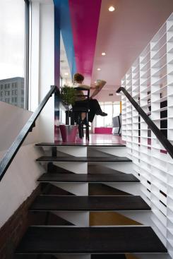 The staircase leading down to the basement level is also made from laser-cut steel, this time coated white. The angular construction of the risers mimics the geometry of the counters and the color fields in the ground floor space--which were achieved using an epoxy coating from Kwasny Flooring and Lining Systems--while the more sedate palette of black and white transitions into the less visually energetic brick space below.