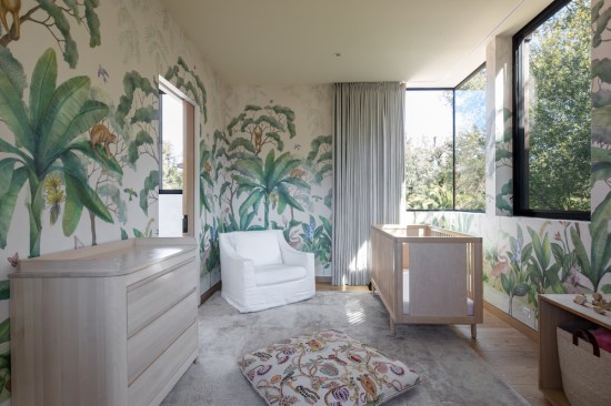 In the nursery, the custom wallpaper mural and frameless corner window overlooking the atrium garden reinforces the feeling of living amongst the trees.