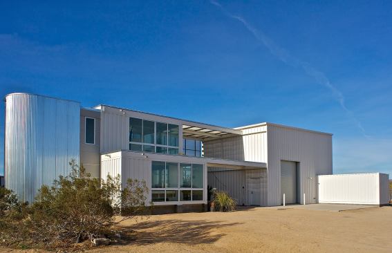 A solar shade canopy wraps the roof and south and west sides of the residence and solar breezeway to provide protection against desert heat, glare, wind, and blowing dust.