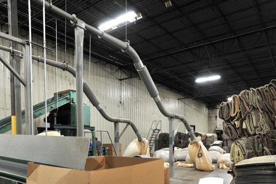 Machines separate and gather the post-consumer carpet fibers from its backing.