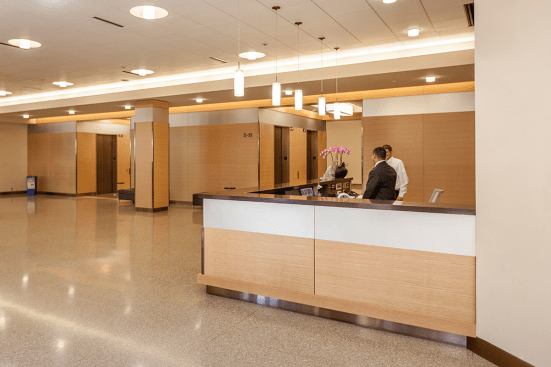 Reception desk, wall accents and elevator transoms in ViviChrome Chromis glass with Taupe interlayer and Opalex finish at Lloyd Center Tower, Portland, Oregon