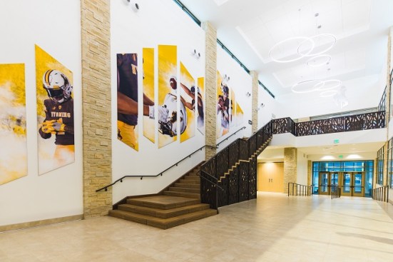 The beautifully designed lobby inside of the Wyoming Rochelle Athletic Center features custom brand components and a donor recognition wall