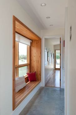 A wood-lined window seat turns a corridor into a living space.