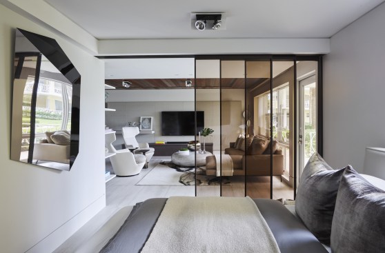 Bronzed sliding glass doors from Ornane lead to the master bedroom. Previously housing a small closet that connected a Jack-and-Jill bathroom, Jimenez transformed the master bedroom into a modern-contemporary suite with a full walk-in closet and master bathroom refuge.