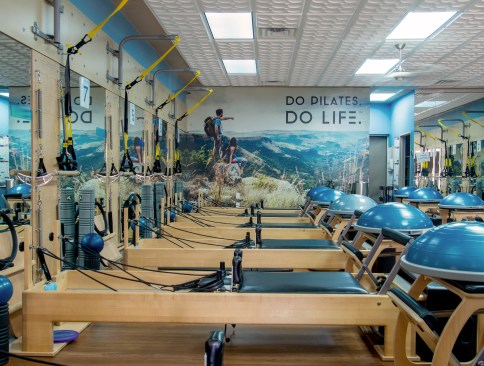 The first studio in the chain, in a Culver City shopping center, set the basic style for all the others, with wood wall panels to match the exercise equipment, a blue accent on the upper wall, and a three-dimensional ceiling that gives the customers something pleasant to look at while working out on their backs.