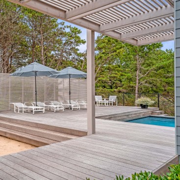 The pool deck uses a cedar slat screen wall to screen the neighbors from view.