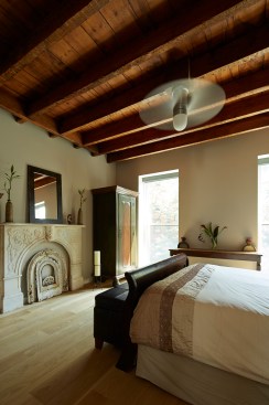 The main bedroom retains the rustic ceiling joists of the original construction.
