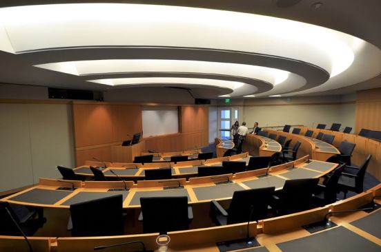 In the amphitheater, the ceiling is the luminaire. Dimmable  T5HO fluorescent strips are concealed above and MR16 HIR adjustable accents  provide targeted illumination of the speaker at the front of the room.