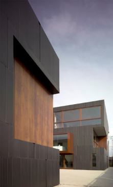 The main house is located toward the rear of the lot, creating a courtyard between the two volumes and offering views of the nearby nursery.