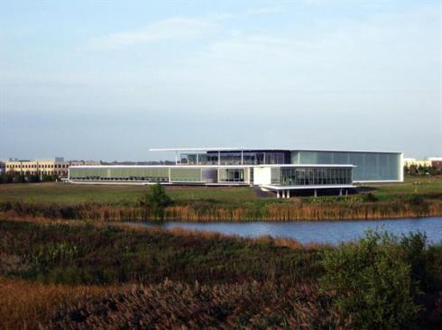 A two-story volume on the east side of the building houses R&D facilities as well as a large public showroom. Channel glass continues the vocabulary of glass bordered by concrete, while obscuring the more industrial space within.