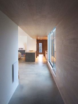 An oak ceiling at the entryway continues into the kitchen, laundry, and utility room, visually dividing the entry and service spaces from the main living area.