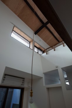 Daylight from the upstairs windows in the double-height space permeates the downstairs bathroom through the transom window. The clerestory window on the bathroom back wall also provides light