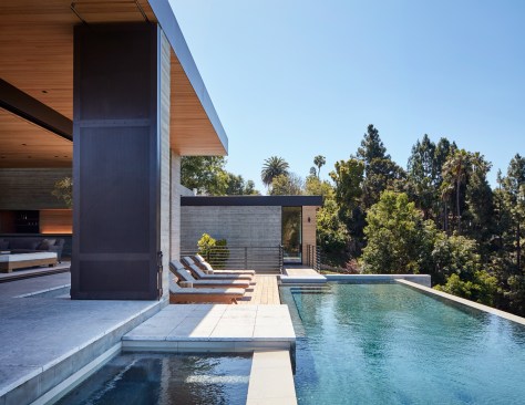 Operable walls pull abundant daylighting deep into the common spaces. A custom screen system can be deployed to counteract strong coastal wind patterns or mitigate afternoon heat gain. When not in use, the six perforated metal panels stack in sets of three against two concrete columns maintaining the home’s contemporary aesthetic. 