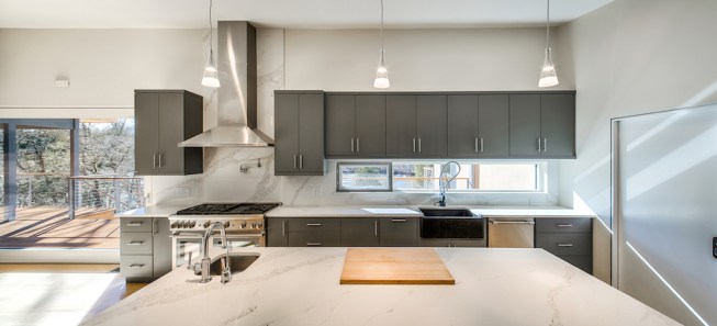 Custom-designed gray cabinets are separated from the countertops by custom backsplash windows for the view and natural ventilation.