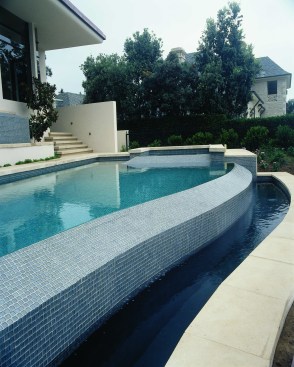 Beautiful look at the custom design, iridescent Oceanside Glasstile undulating overflow edge and return trough on the Oceanside of this custom pool designed and surfaced by Jimmy Reed, president of Rock Solid Tile in Los Angeles.
 