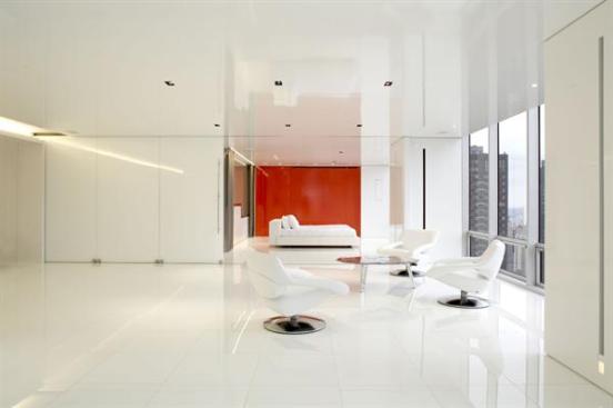 A glass wall separates the master bedroom from the rest of the apartment.
