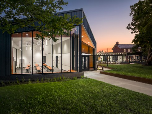 A courtyard extends between the addition and the historic house.