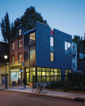 The composition of the Cor-Ten steel panel facade recalls the openings in the original masonry structure.